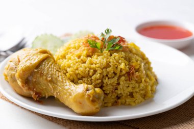 Beyaz arka planda tavuk ve acı soslu Tayland biryani pilavı.