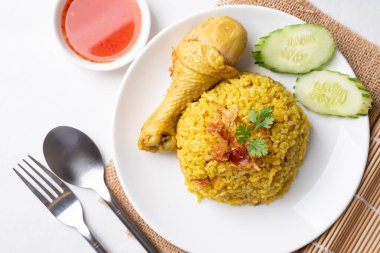 Beyaz arka planda tavuk ve acı soslu Tayland biryani pilavı.