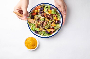 Marullu sağlıklı sebze salatası, kinoa tohumu, azuki fasulyesi, mısır, domates, balkabağı ve mor patatesli kabak kabağı soslu beyaz arka planda. Vejetaryen ve bitkisel gıda