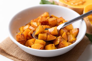 Roasted butternut squash pumpkin in a bowl with spoon, Autumn homemade food
