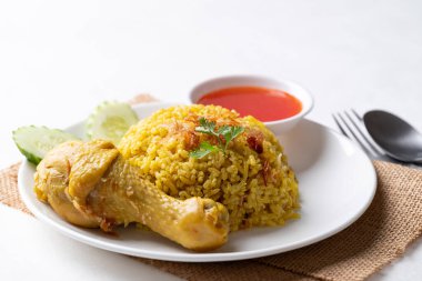 Beyaz arka planda tavuk ve acı soslu Tayland biryani pilavı.