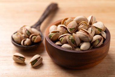 Ahşap arka planda kaşık içinde kavrulmuş fıstık.