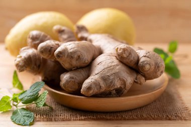 Tahta arka planda taze zencefil ve limon.