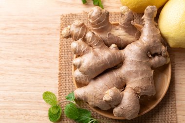 Ahşap zemin üzerinde taze zencefil ve limon, masa üstü görünümü