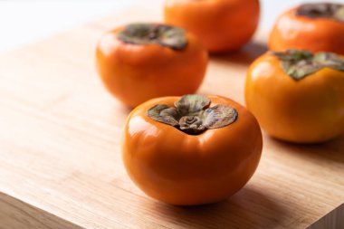 Ahşap arka planda olgun hurma meyvesi, sonbahar meyvesi