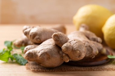 Tahta arka planda taze zencefil ve limon.