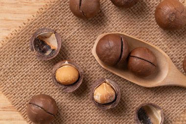 Macadamia nuts on brown background, Top view