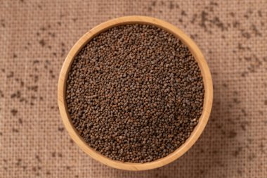 Kahverengi arka planda bir kasede kurutulmuş perilla tohumu.