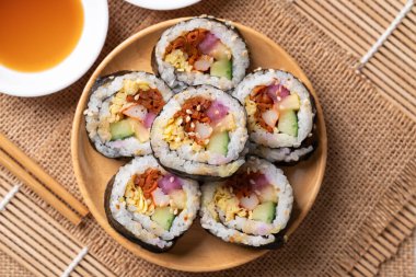 Kimbap veya Gimbap, sebzeli pilav, yumurta ve kurutulmuş yosunla sarılmış Kore yemeği.