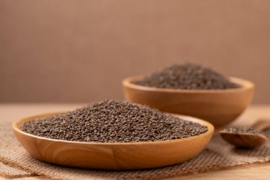 Kahverengi arka planda ahşap kasede kurutulmuş perilla tohumu.