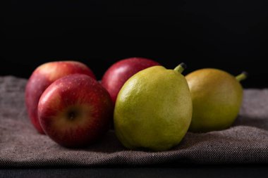 Siyah arka planda kırmızı elma ve armut meyvesi