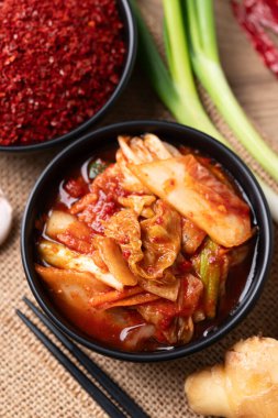 İçinde malzemeler ve Kore yemeği olan bir kasede kimçi lahanası.