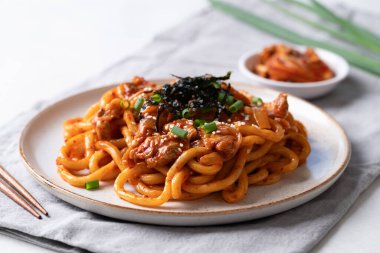 Kızarmış Udon şehriyesini lahana, domuz eti, taze soğan, susam tohumu ve deniz yosunuyla karıştır.