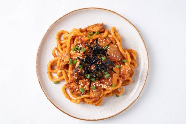 Kızarmış Udon şehriyesini lahana, domuz eti, taze soğan, susam tohumu ve deniz yosunuyla karıştır.