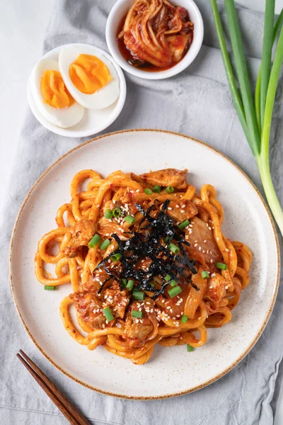 Kızarmış Udon şehriyesini lahana, domuz eti, taze soğan, susam tohumu ve deniz yosunuyla karıştır.