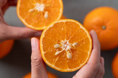 Mandalina portakal meyvesinin yarısı elle tutulur, Üst Manzara