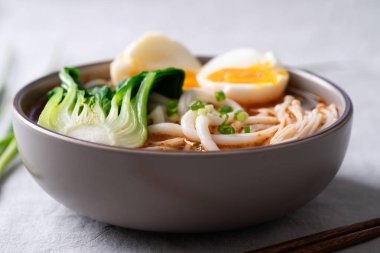 Baharatlı Udon Erişte Çorbası. Üstünde Bok Choy, Enoki Mantarı ve yumuşak kaynamış yumurta var.