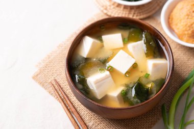Yumuşak tofu ile sağlıklı Japon miso çorbası ve yemek çubuklarıyla ahşap bir kasede yosun.