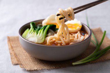 Baharatlı Udon Erişte Çorbası. Üstünde Bok Choy, Enoki Mantarı ve yumuşak kaynamış yumurta var.