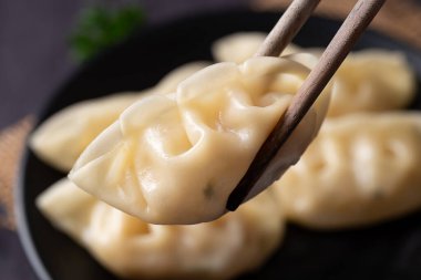 Buharda pişmiş bir hamur köftesinin yemek çubuklarıyla toplanmasına yakın.