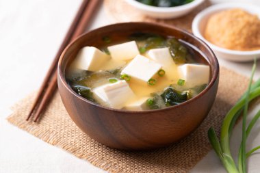 Yumuşak tofu ile sağlıklı Japon miso çorbası ve yemek çubuklarıyla ahşap bir kasede yosun.