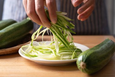 Taze kabaklı şehriye (zoodles) beyaz bir tabakta, sağlıklı yemek için hazırlanmış.