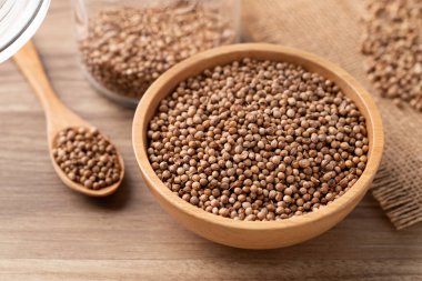 Tahta bir kasede kişniş tohumları ve ahşap bir arka planda kaşık, Tayland besin maddeleri.