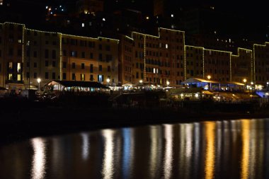 Gece ışıkları denizi yansıtıyor.