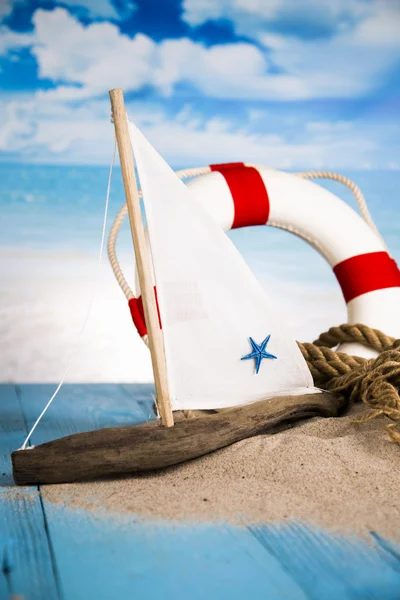 Holiday by the sea, lighthouse, seagull, lifebuoy, sand, shells — Stock Photo, Image