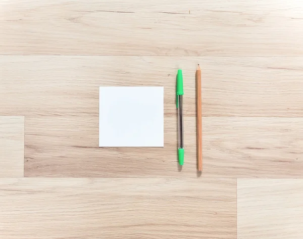 Blank paper, pen and pencils on the wooden table. View from above