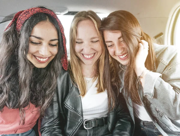 Молодые Дружелюбные Девушки Веселятся Смартфоном Сидящим Машине Счастливая Мультирасовая Группа — стоковое фото