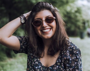 Doğa parkında gülümseyen muhteşem bir kızın portresi bulanık arkaplan filtresi.