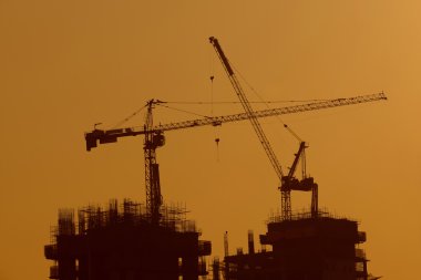 Silhouette of Tower Cranes at Construction Site. clipart