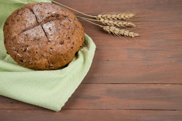 Bread with home-baked cereals on a light napkin with spikelets. Horizontal orientation.Place for a copy space