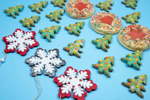 Рождественское домашнее печенье и декоративные снежинки, выложенные рядами на синем фоне.. — стоковое фото