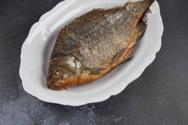 Kızarmış balığın beyaz tabakta yakın çekimi. Hafif arkaplan, alanı kopyala