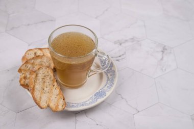 Öğle yemeği için bir fincan sıcak et suyu ve hafif arka planda kızarmış beyaz ekmek. Boşluğu kopyala