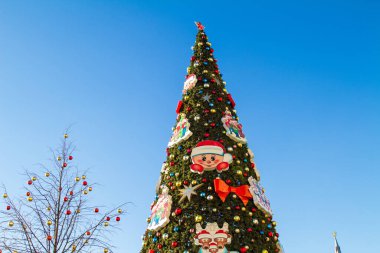 Moskova 'nın merkezinde güneşli bir günde mavi gökyüzüne karşı suni Noel ağacı. Yatay yönelim