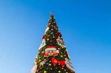 Güneşli bir günde mavi gökyüzü arka planında suni Noel ağacı. Yatay yönelim