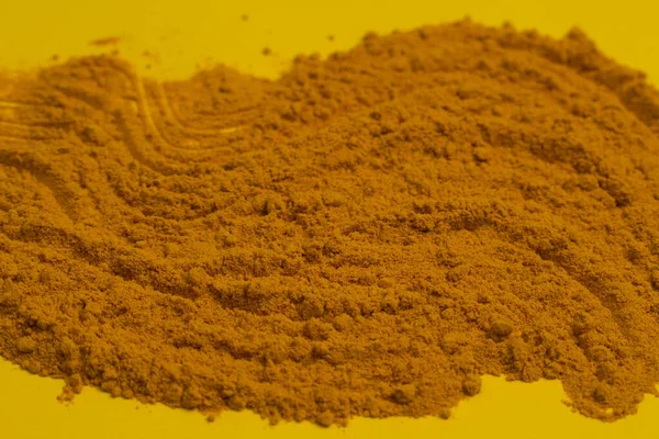 Primo piano di polvere di curcuma macinata su fondo giallo. Copia spazio — Foto Stock