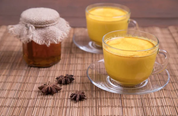 Deux tasses de lait doré avec du miel et des étoiles d'anis. tendance asiatique désintoxication boisson pour végétaliens — Photo
