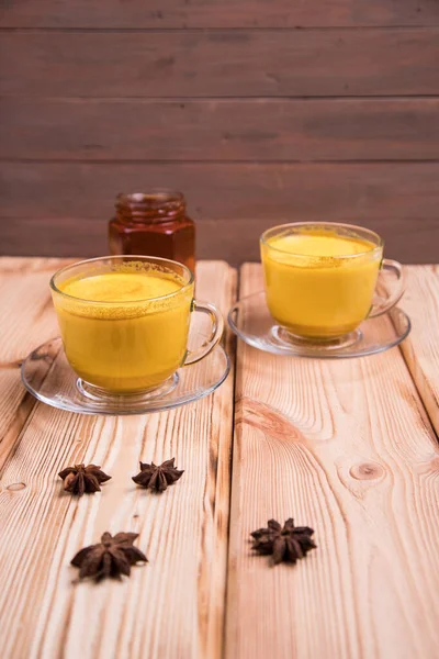 Golden Milk boisson antioxydante avec curcuma et miel sur un fond en bois. Le curcuma aide à brûler des calories. Le lait doré aide à restaurer le collagène . — Photo