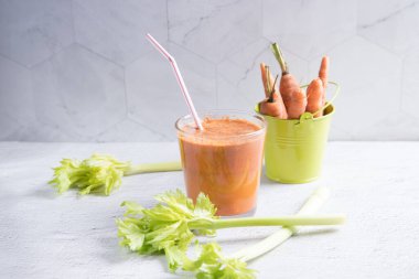 Havuç suyu ve arka planda bir kova havuç. Detoks diyeti kavramı