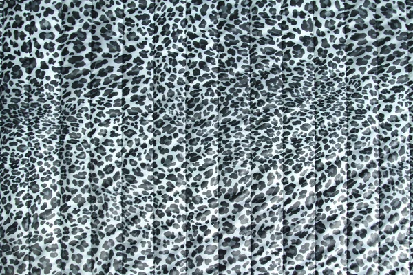 Fashionable leopard-print quilted fabric in grey. Abstract background with leopard pattern .