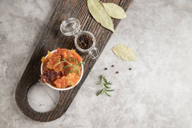 Karabiber biberiyeli kurutulmuş et parçaları ve ahşap kesim tahtasında defne yaprağı. Susuz kalmış ürün. Boşluğu kopyala