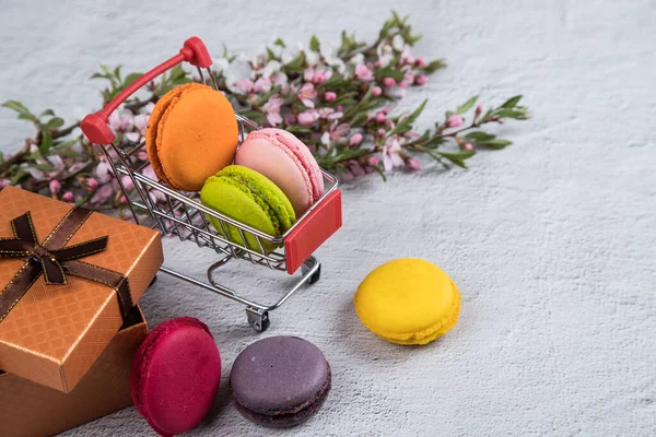 Souvenir food cart filled with colorful macaroons cookies. Sweet gift concept