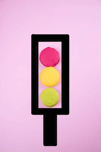 Semáforo hecho de galletas de macarrones sobre un fondo de papel rosa. Copiar espacio — Foto de Stock