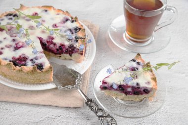 Ev yapımı çilekli turta ve bir fincan çayla birlikte beyaz bir tabağın üzerine koydu. Ev çayı içme konsepti