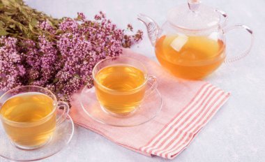 İki fincan ve bir çaydanlık kekikli çay..