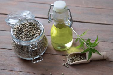 Ahşap bir masada vitamin ve mineral açısından zengin kenevir tohumu yağı yakın plan. Alternatif yağ